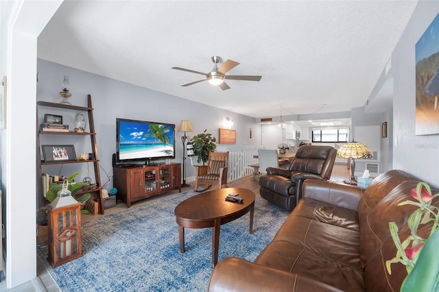 living area featuring a ceiling fan and a textured ceiling