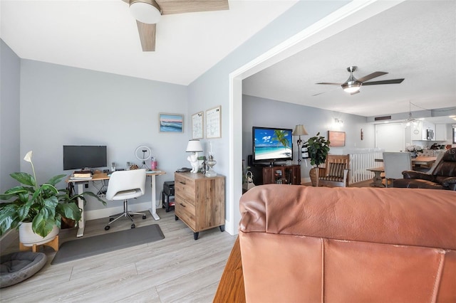 living room with a ceiling fan and light wood-style floors