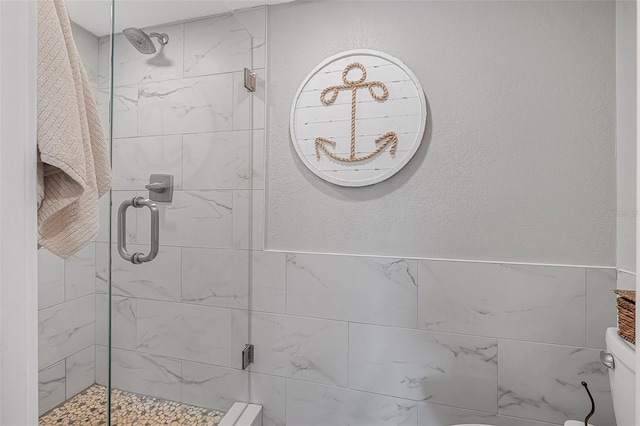 bathroom with a stall shower and toilet