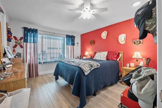 bedroom with a ceiling fan, wood finished floors, and a textured ceiling