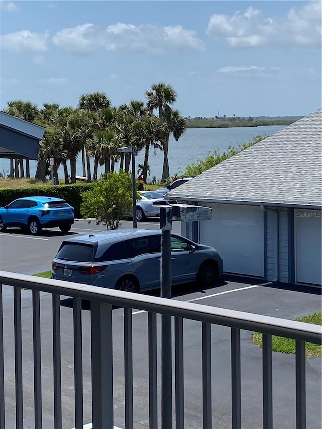 uncovered parking lot featuring a water view