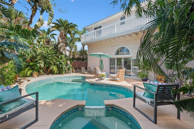 view of pool with a patio, a fenced in pool, an in ground hot tub, and fence