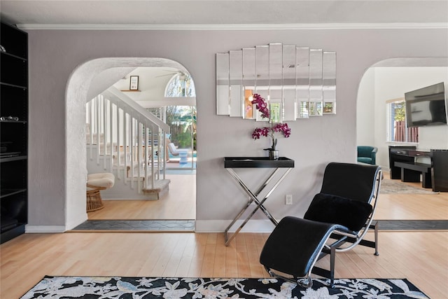 entryway featuring stairway, a wealth of natural light, hardwood / wood-style floors, and arched walkways