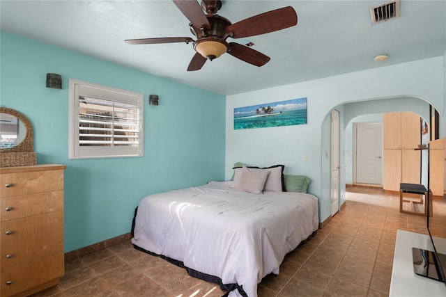 bedroom with tile patterned floors, visible vents, a ceiling fan, and baseboards