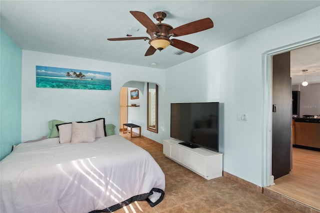 bedroom with visible vents, a ceiling fan, and arched walkways
