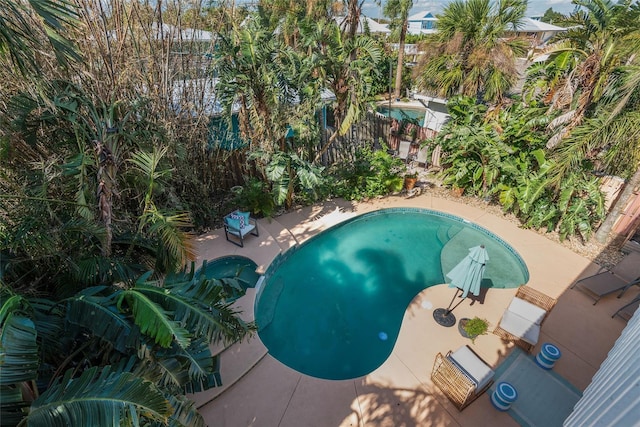 view of pool featuring fence, a patio area, and a pool with connected hot tub