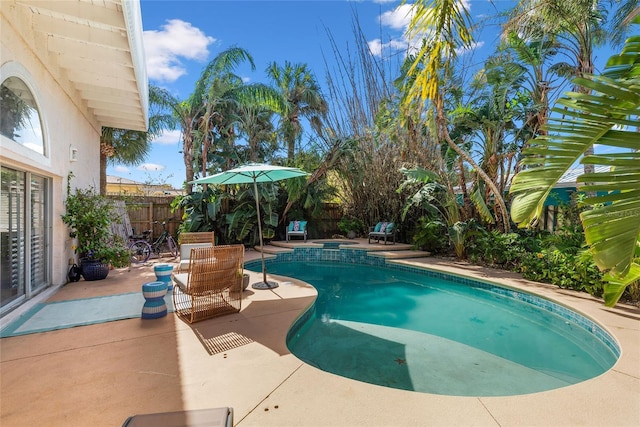 view of swimming pool with a pool with connected hot tub, a patio, and a fenced backyard