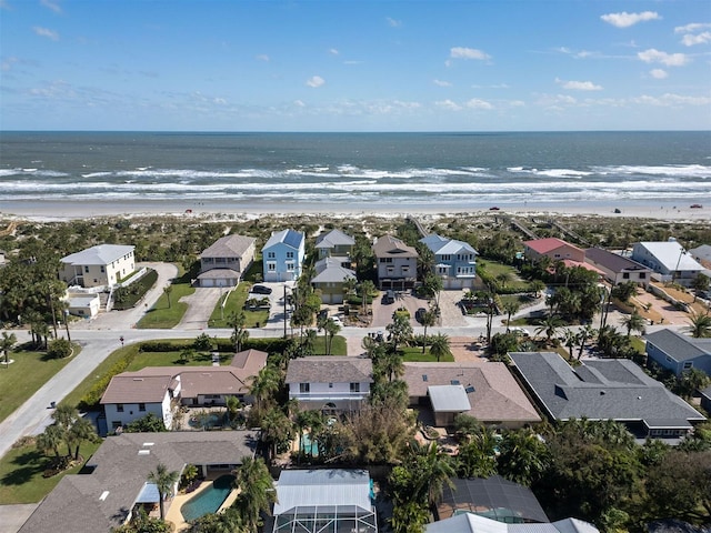 drone / aerial view featuring a residential view, a beach view, and a water view