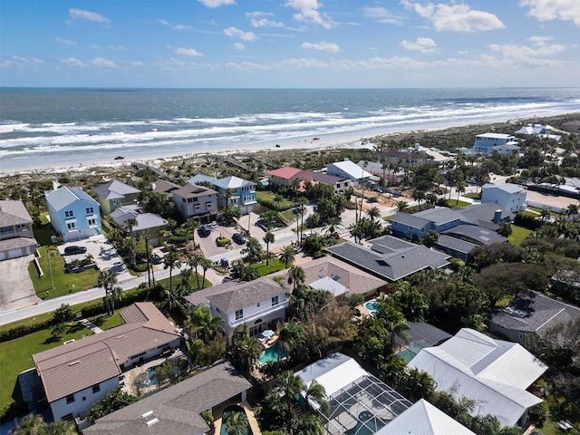 aerial view with a view of the beach, a water view, and a residential view