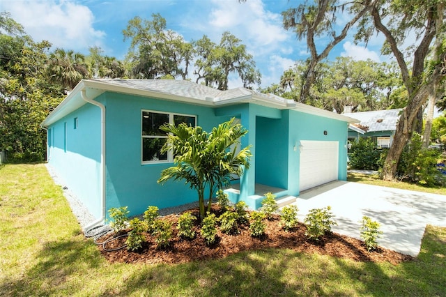 exterior space featuring a front lawn, stucco siding, driveway, roof with shingles, and a garage