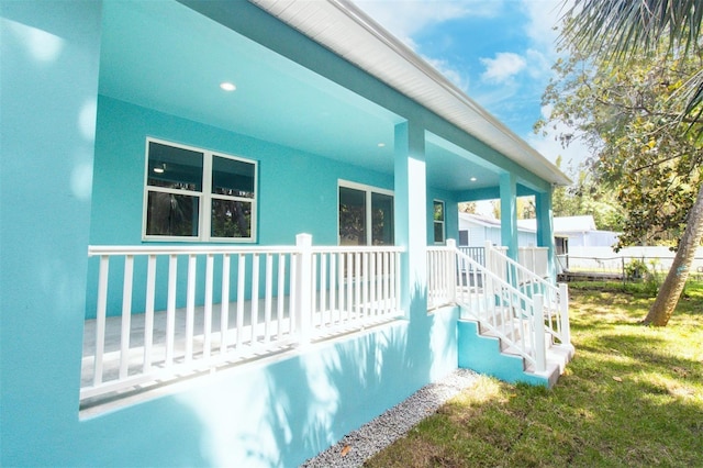 exterior space with a lawn, stucco siding, and covered porch