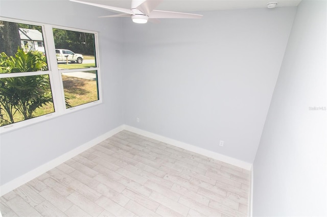 spare room featuring baseboards, a ceiling fan, and wood finished floors