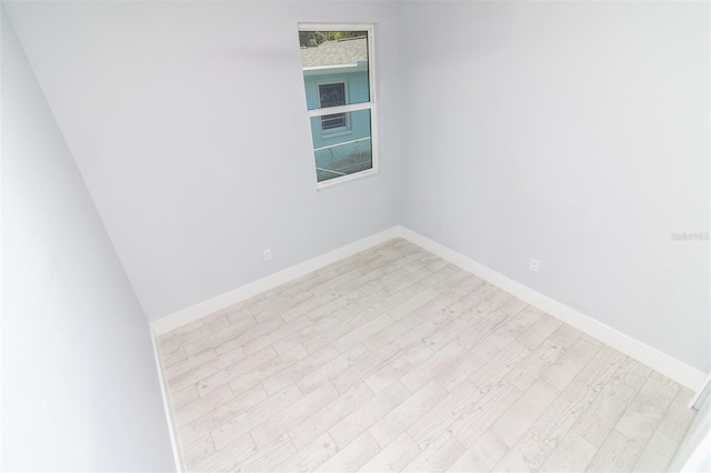 spare room featuring light wood-style flooring and baseboards