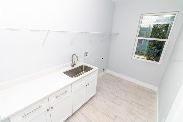 clothes washing area with a sink, hookup for a washing machine, baseboards, electric dryer hookup, and cabinet space