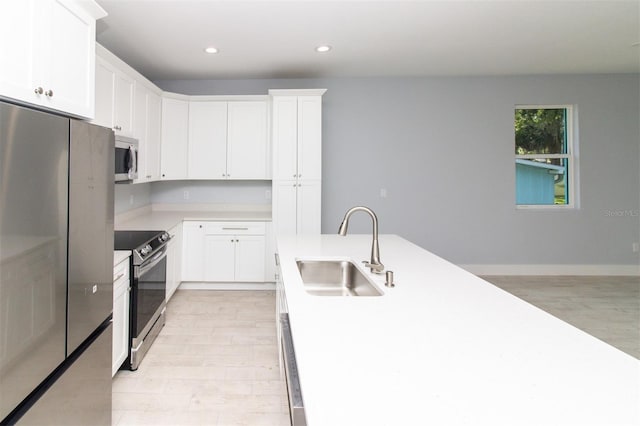 kitchen with a sink, recessed lighting, light wood-style floors, light countertops, and appliances with stainless steel finishes
