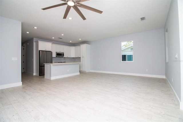 unfurnished living room with a ceiling fan, light wood finished floors, visible vents, and recessed lighting