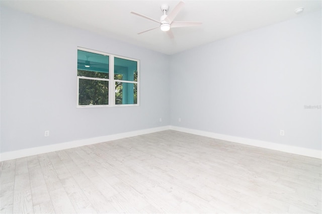 empty room featuring ceiling fan, baseboards, and wood finished floors