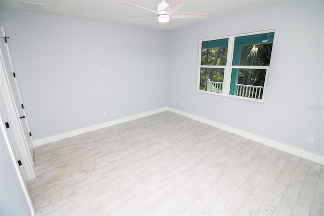 spare room featuring wood finished floors, a ceiling fan, and baseboards