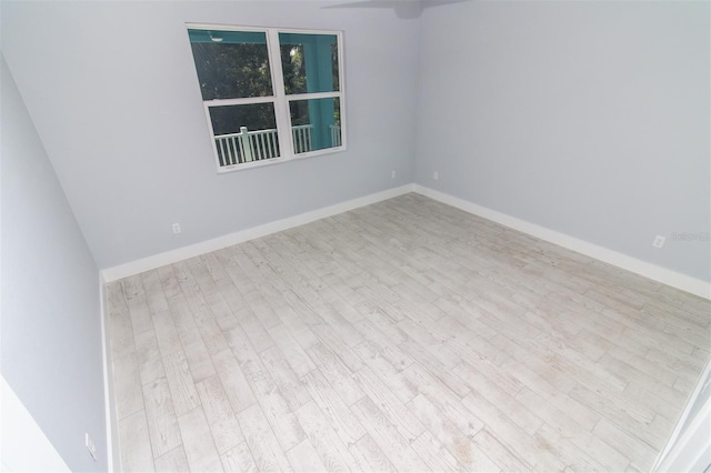 spare room with wood finished floors and baseboards