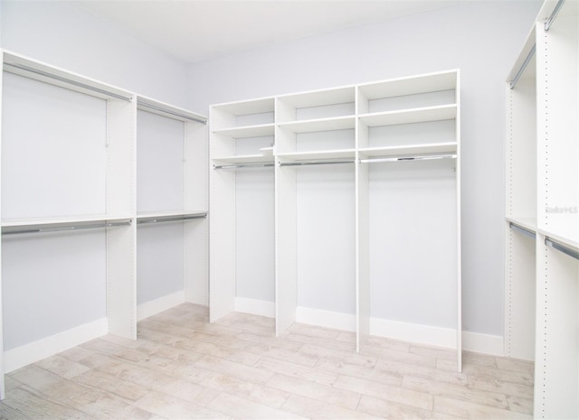 walk in closet with light wood-style flooring