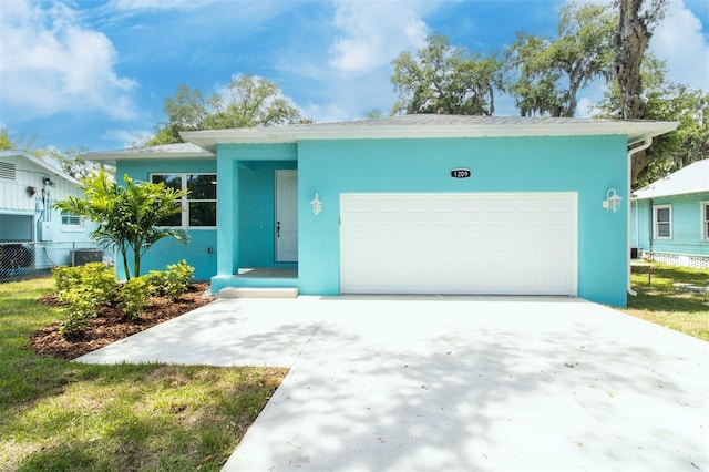 view of front facade featuring fence, central air condition unit, stucco siding, driveway, and a garage