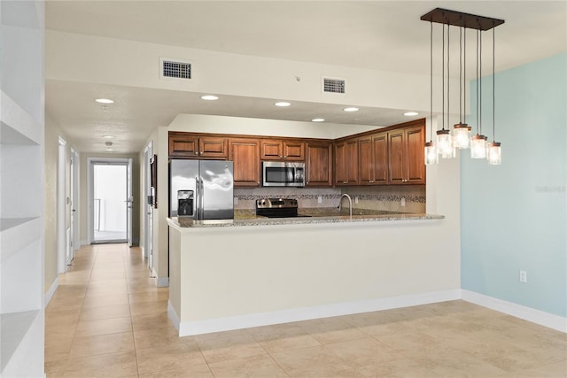 kitchen featuring light stone countertops, visible vents, a peninsula, and stainless steel appliances