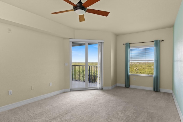 spare room with baseboards, light carpet, and ceiling fan