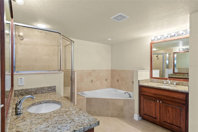 bathroom with a textured ceiling, visible vents, a stall shower, and a sink