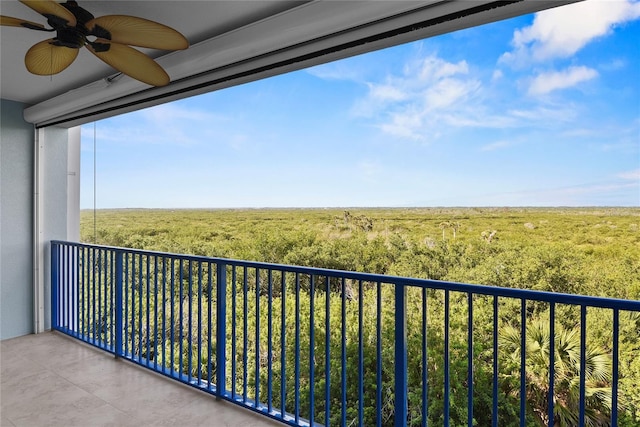 balcony with ceiling fan and a view of trees