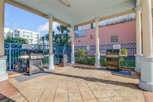 view of patio featuring a grill and fence