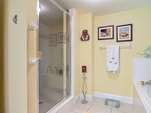3145 S Atlantic Ave Unit 1001, Daytona Beach, FL 32118 - bathroom featuring baseboards, a stall shower, a garden tub, and tile patterned flooring