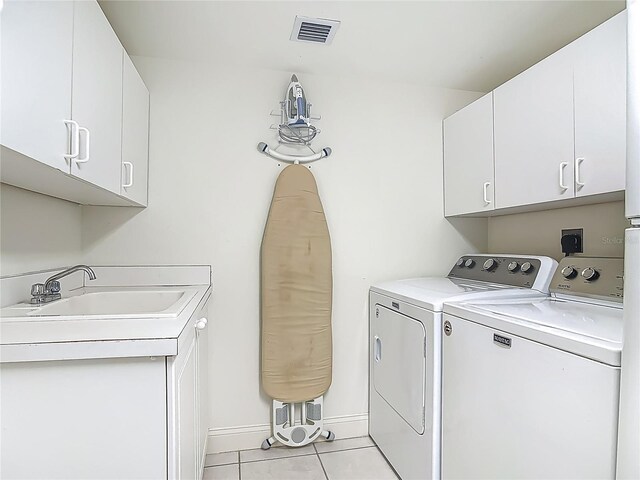 3145 S Atlantic Ave Unit 1001, Daytona Beach, FL 32118 - clothes washing area featuring light tile patterned floors, cabinet space, washing machine and clothes dryer, a sink, and visible vents