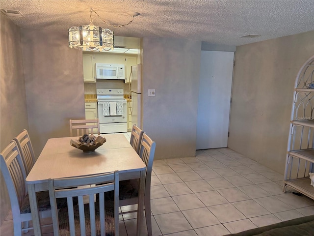 4175 S Atlantic Ave Unit 5280, New Smyrna Beach, FL 32169 - dining area featuring a chandelier, a textured ceiling, and light tile patterned flooring