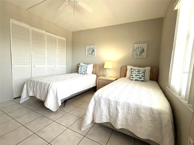 4175 S Atlantic Ave Unit 5280, New Smyrna Beach, FL 32169 - tiled bedroom featuring a closet, a ceiling fan, and a textured ceiling