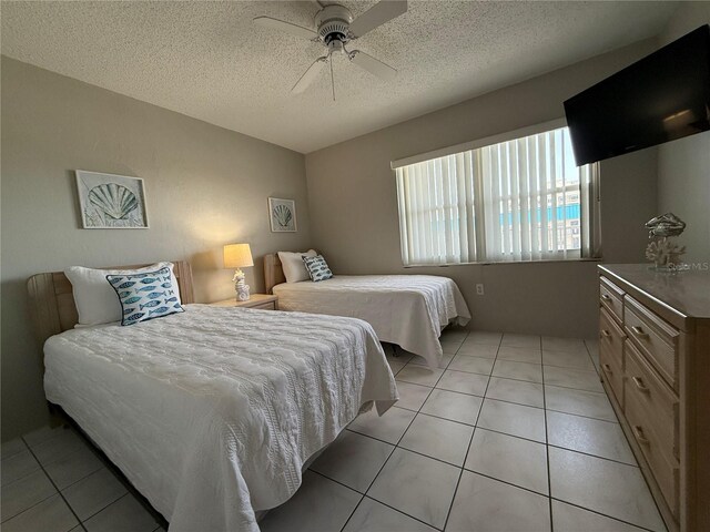 4175 S Atlantic Ave Unit 5280, New Smyrna Beach, FL 32169 - bedroom with a textured ceiling, light tile patterned flooring, and ceiling fan
