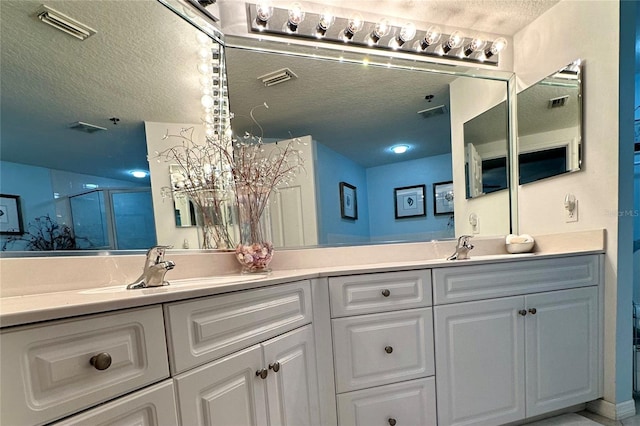 5300 S Atlantic Ave Unit 8-402, New Smyrna Beach, FL 32169 - bathroom with a sink, an enclosed shower, visible vents, double vanity, and a textured ceiling