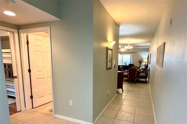 5300 S Atlantic Ave Unit 8-402, New Smyrna Beach, FL 32169 - corridor featuring baseboards, an inviting chandelier, and light tile patterned flooring