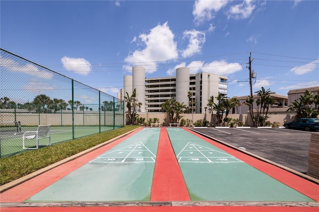 4501 S Atlantic Ave Unit 415, New Smyrna Beach, FL 32169 - view of community featuring uncovered parking, shuffleboard, and fence