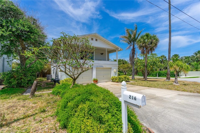 216 Dune Cir, New Smyrna Beach, FL 32169 - coastal inspired home with concrete driveway and an attached garage