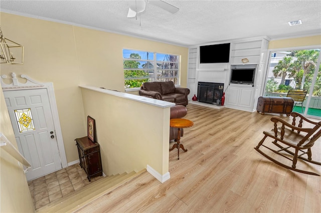 216 Dune Cir, New Smyrna Beach, FL 32169 - living room featuring a ceiling fan, a textured ceiling, and light wood finished floors