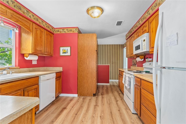 216 Dune Cir, New Smyrna Beach, FL 32169 - kitchen with light wood finished floors, a sink, white appliances, visible vents, and light countertops
