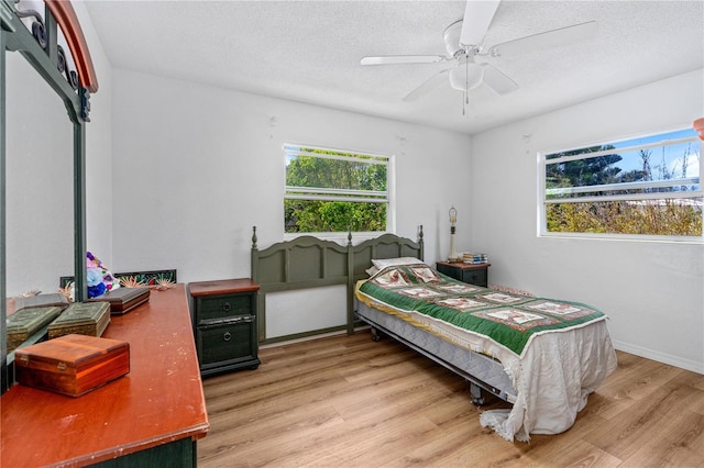 216 Dune Cir, New Smyrna Beach, FL 32169 - bedroom featuring a textured ceiling, light wood-type flooring, and multiple windows