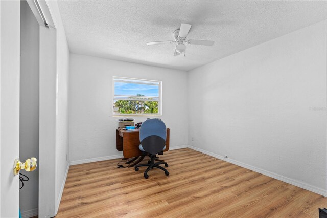 216 Dune Cir, New Smyrna Beach, FL 32169 - unfurnished office featuring a textured ceiling, light wood-style floors, and a ceiling fan