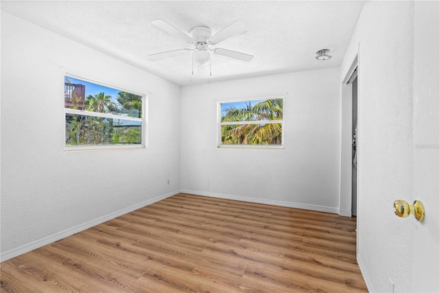216 Dune Cir, New Smyrna Beach, FL 32169 - unfurnished bedroom with a textured ceiling, a ceiling fan, wood finished floors, and baseboards
