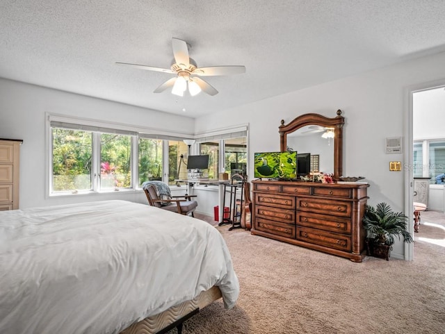 bedroom with connected bathroom, a textured ceiling, ceiling fan, and carpet