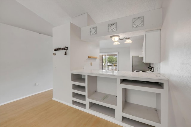 160 Reserve Cir Unit 204, Oviedo, FL 32765 - kitchen featuring open shelves, baseboards, white cabinets, tile counters, and light wood-style flooring