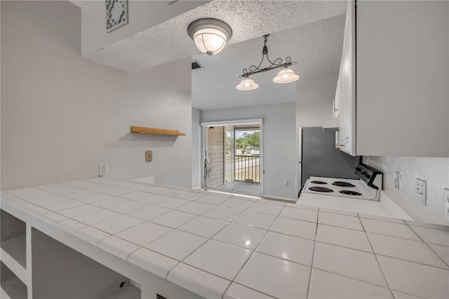 160 Reserve Cir Unit 204, Oviedo, FL 32765 - kitchen featuring range with electric stovetop, tile countertops, a textured ceiling, under cabinet range hood, and white cabinetry