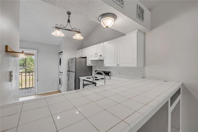 160 Reserve Cir Unit 204, Oviedo, FL 32765 - kitchen featuring stacked washer / dryer, freestanding refrigerator, lofted ceiling, white electric range oven, and under cabinet range hood