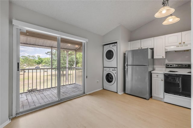 160 Reserve Cir Unit 204, Oviedo, FL 32765 - kitchen featuring electric range oven, stacked washer / drying machine, freestanding refrigerator, lofted ceiling, and under cabinet range hood