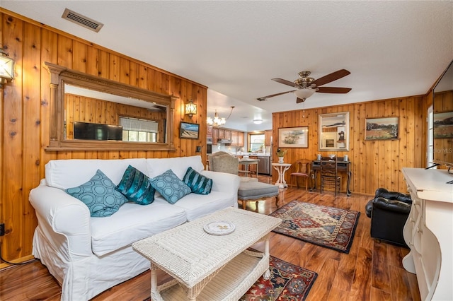 825 E 23rd Ave, New Smyrna Beach, FL 32169 - living area with visible vents, ceiling fan with notable chandelier, wood finished floors, and wooden walls
